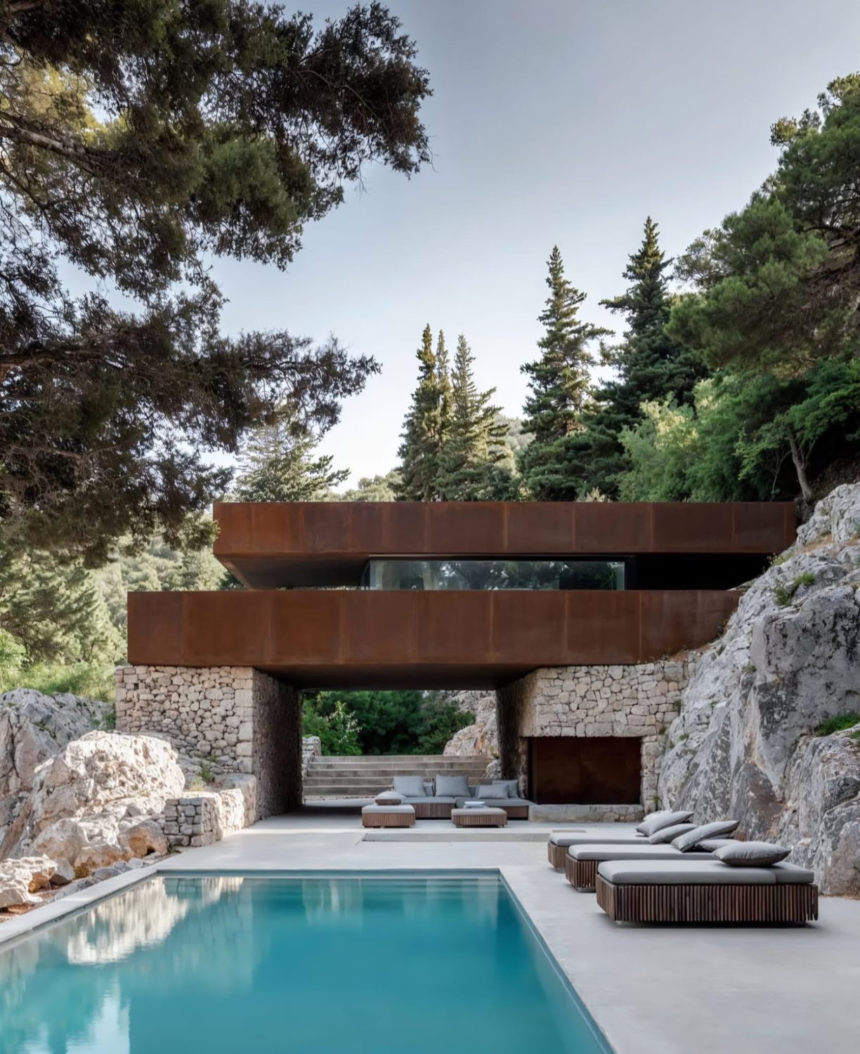Corten steel and stone villa above a pool terrace